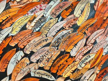 Small carved cedar feathers coloured orange with meaningful words written on them